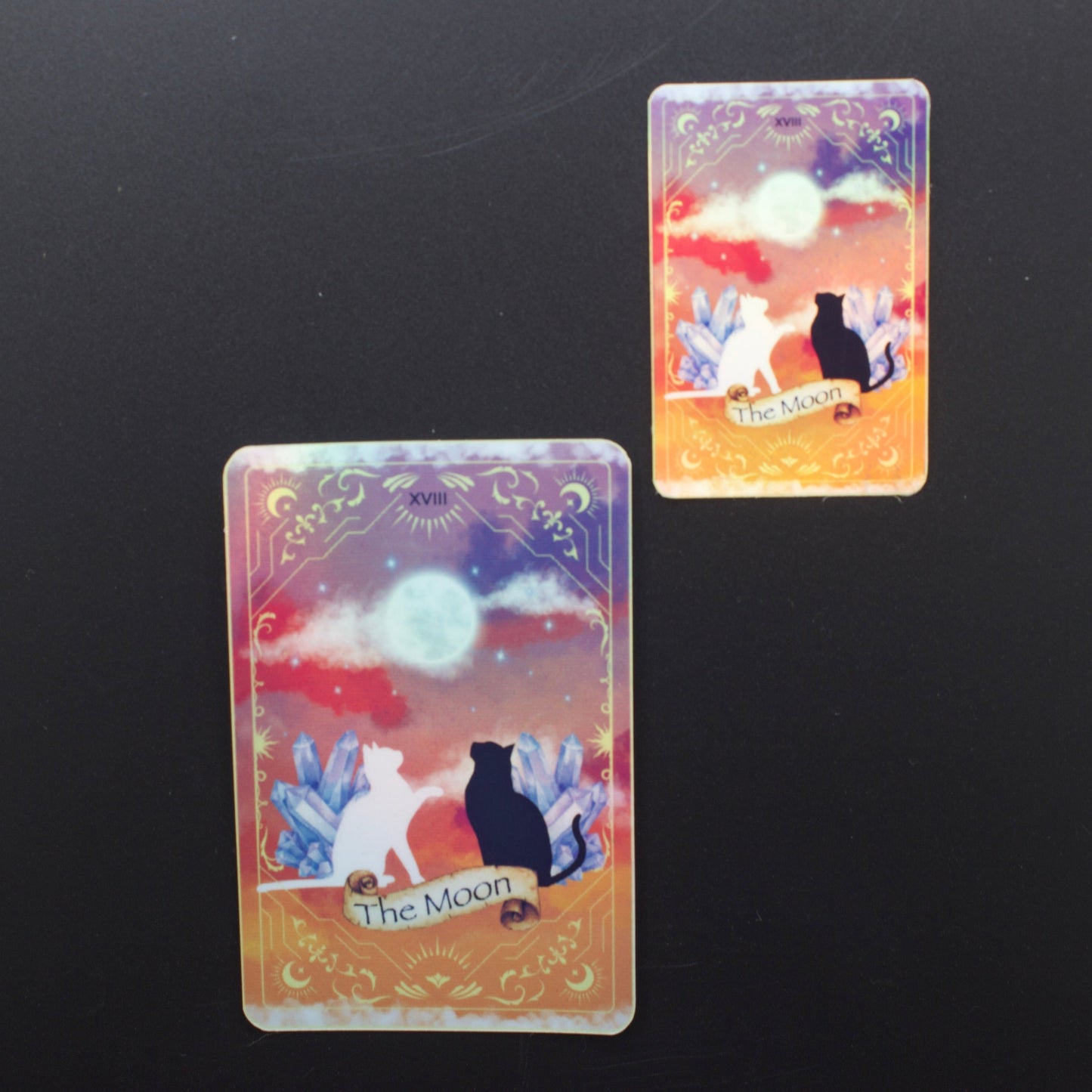 Two tarot cards titled 'The Moon' on a black background
